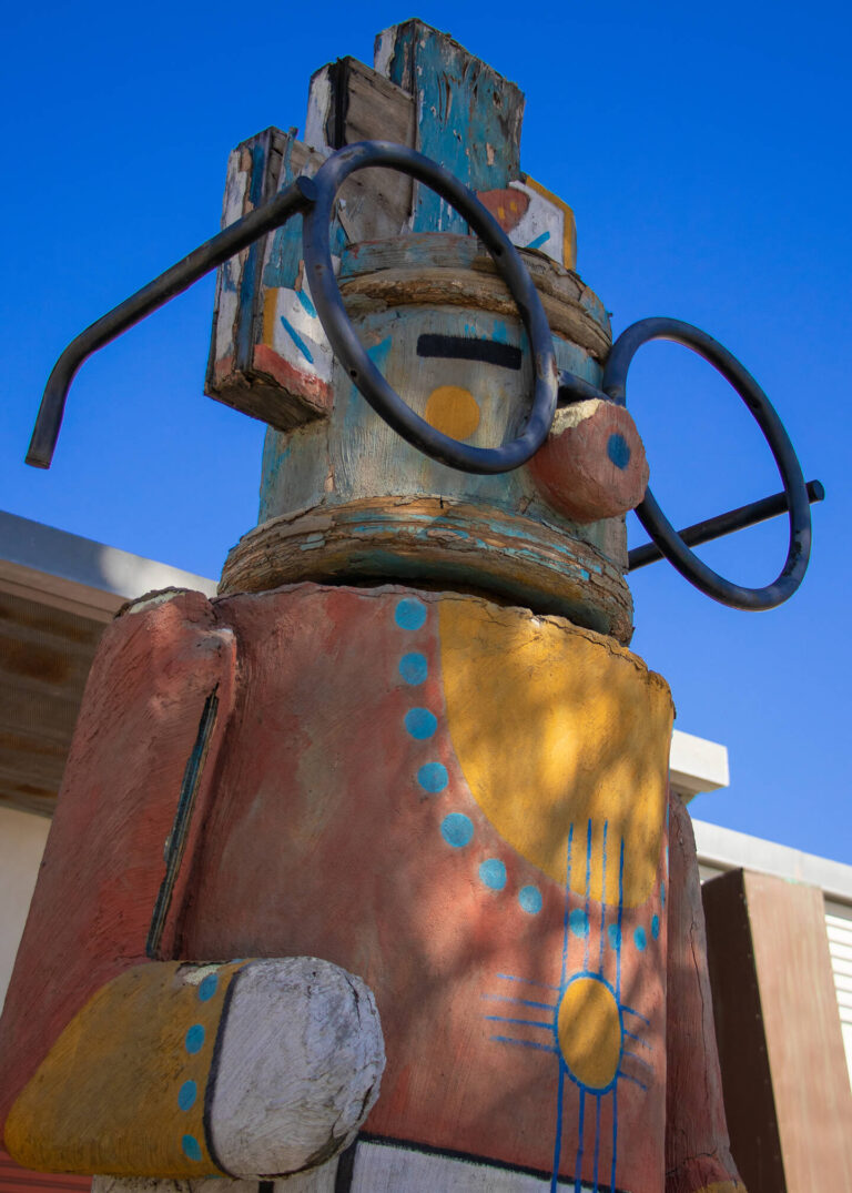 Native American totem pole with glasses and blue beaded necklace
